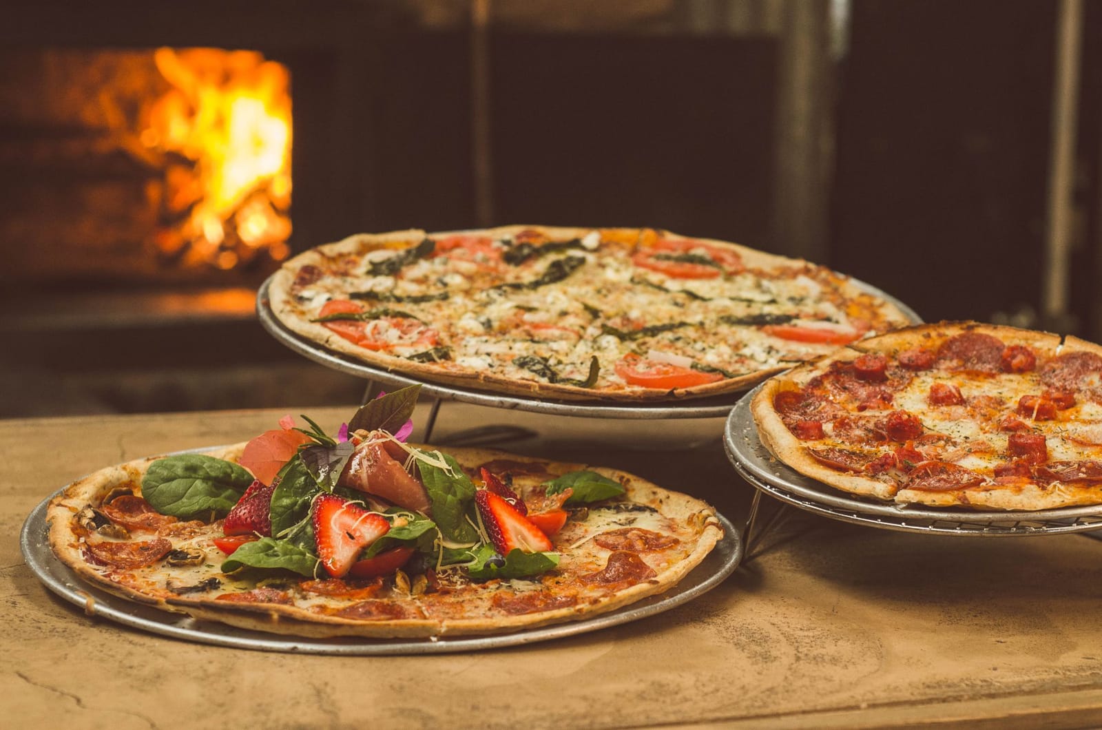 Stimmungsbild: Pizzen vor einem Holzofen